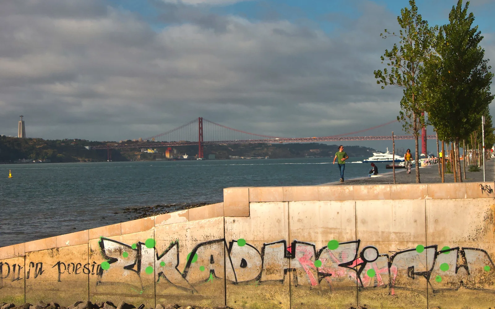 Lisbon waterfront beside the Tagus River with the 25 de Abril Bridge in the distance